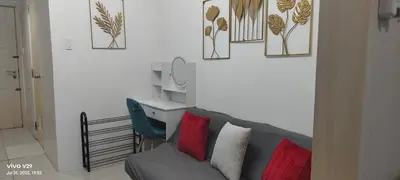 a living room with a gray couch and a mirror at Sea Residences Yanah Staycation in Manila