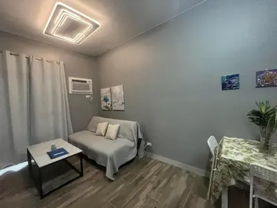 a living room with a bed and a table at Gentry Manor Seaview Family Suite balcony View WiFi Netflix 17S in Manila