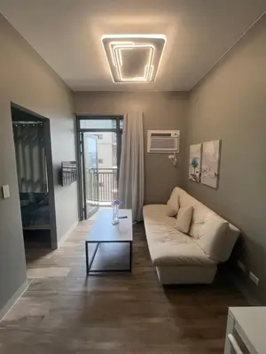a living room with a couch and a table at Gentry Manor Seaview Family Suite balcony View WiFi Netflix 17S in Manila