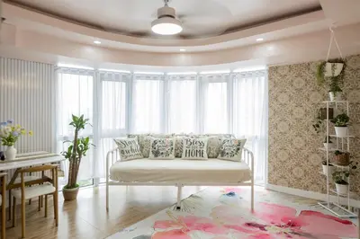 a living room with a white couch in front of a window at Devi Suite 2BR BGC Taguig in Manila