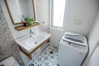 a small bathroom with a sink and a washing machine at Devi Suite 2BR BGC Taguig in Manila