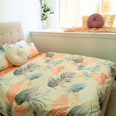 a bed with a floral comforter in a bedroom at Casa Solana at SMDC South Residences in Manila