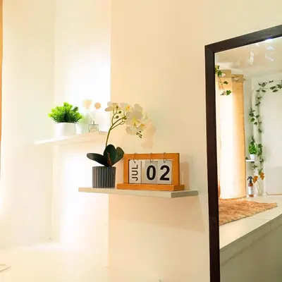 a mirror and a clock on a shelf in a room at Casa Solana at SMDC South Residences in Manila