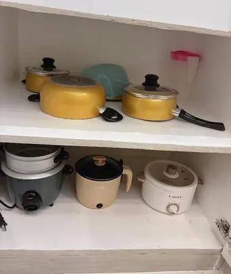 a shelf with many pots and pans on it at Cozy Loft Condo in Tanza with Arcade in Tanza