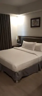 a large bed in a hotel room at Superior Studio Urban Escapes at BCCT in Manila