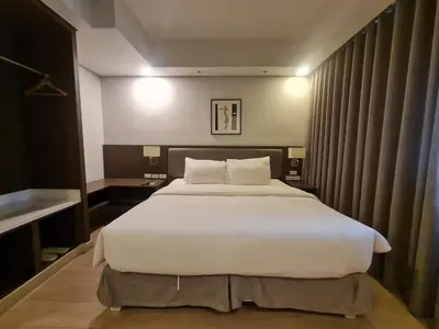 a bedroom with a large bed with white sheets at Superior Studio Urban Escapes at BCCT in Manila