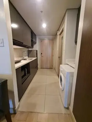 a kitchen with a washer and dryer in a room at Superior Studio Urban Escapes at BCCT in Manila