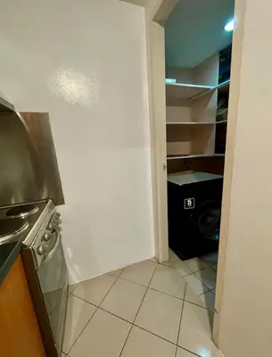 a kitchen with a washer and dryer in a room at Forbeswood Parklane Condominium in Manila