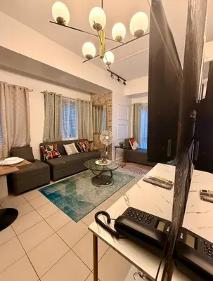 a living room with a couch and a television at Forbeswood Parklane Condominium in Manila