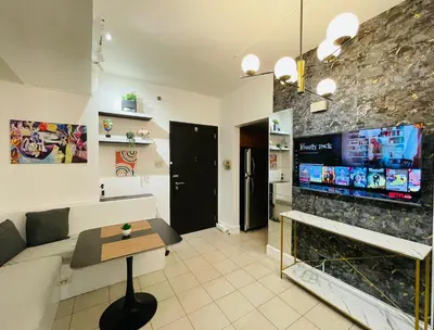a living room with a couch and a tv at Forbeswood Parklane Condominium in Manila