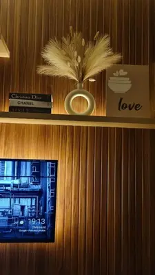 a shelf with a vase of flowers and books at The C Place Mla in Manila