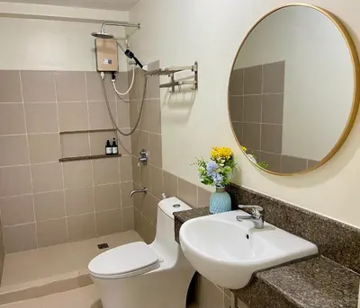 a bathroom with a sink and a toilet and a mirror at V-TAN condo in Manila