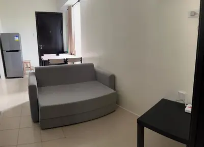 a living room with a couch and a table at Cozy Nook in the City in Manila
