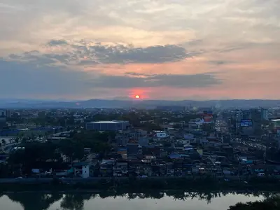 a view of a city with the sunset in the background at Cozy Nook in the City in Manila