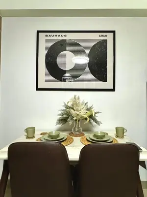 a dining room table with two chairs and a picture on the wall at Philhaus Staycation in Manila