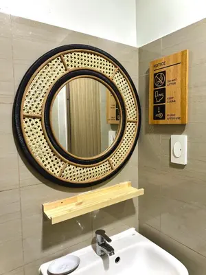 a bathroom with a round mirror above a sink at Philhaus Staycation in Manila