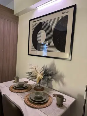 a table with plates and cups and a picture on the wall at Philhaus Staycation in Manila