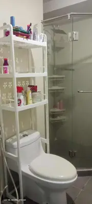 a bathroom with a toilet and a glass shower at Capsule bed room in Manila