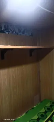 a wooden shelf on top of a wooden wall at Capsule bed room in Manila