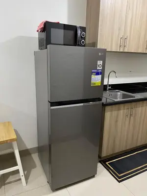 a kitchen with a refrigerator and a sink at Teychi's Staycation at Shore2 MOA Pasay in Manila