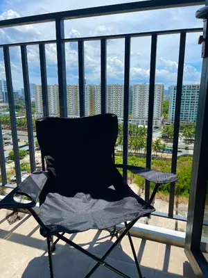 a chair on a balcony with a view of a city at Teychi's Staycation at Shore2 MOA Pasay in Manila