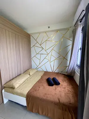 a bedroom with a bed with two shoes on it at Teychi's Staycation at Shore2 MOA Pasay in Manila