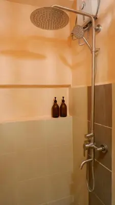a shower with two bottles on a shelf in a bathroom at Zen Staycation with City and Sunset View near Airport and Mckinley in Manila