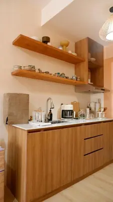 a kitchen with wooden cabinets and a counter top with a sink at Zen Staycation with City and Sunset View near Airport and Mckinley in Manila