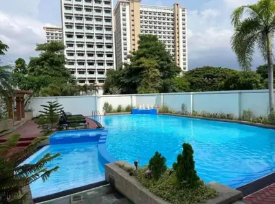a large blue swimming pool with buildings in the background at WestParc Cedar Cozy Apartment in the Heart of Alabang in Manila
