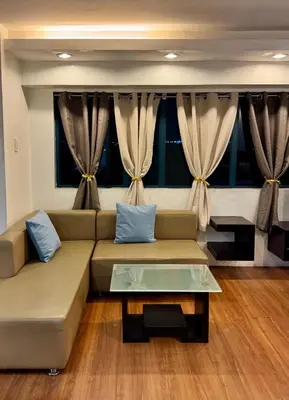 a living room with a couch and a table at WestParc Cedar Cozy Apartment in the Heart of Alabang in Manila