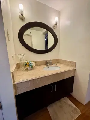 a bathroom with a sink and a mirror at WestParc Cedar Cozy Apartment in the Heart of Alabang in Manila