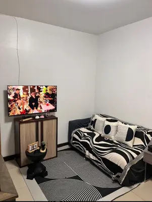 a bedroom with a bed and a flat screen tv at Solemare parksuites in Manila