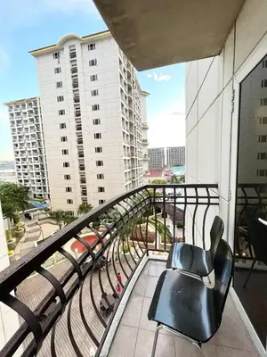 a chair on a balcony with a view of a city at Solemare parksuites in Manila