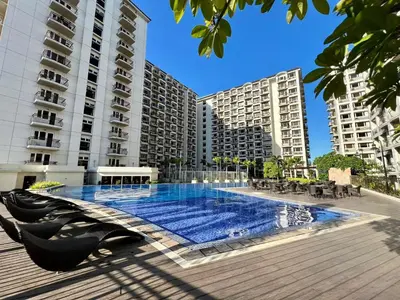 a swimming pool in front of some tall buildings at Solemare parksuites in Manila