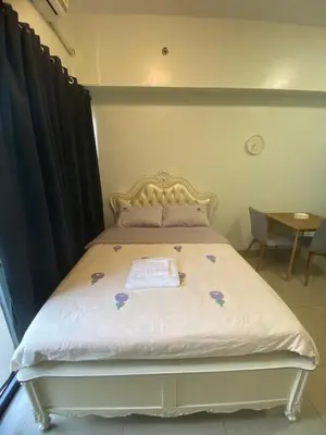 a bedroom with a bed with a gold headboard at Shore 2 Tower 1 in Manila