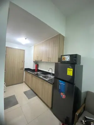 a kitchen with a black refrigerator and a sink at Shore 2 Tower 1 in Manila
