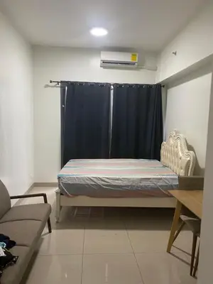 a bedroom with a bed with a blue curtain at Shore 2 Tower 1 in Manila
