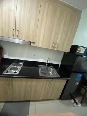 a kitchen with a sink and wooden cabinets at Shore 2 Tower 1 in Manila
