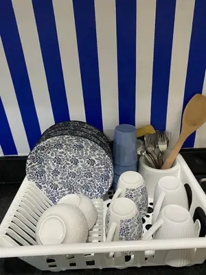 a dishrack filled with dishes and plates and utensils at Sea Residences Santorini Vibes - Reynil in Manila