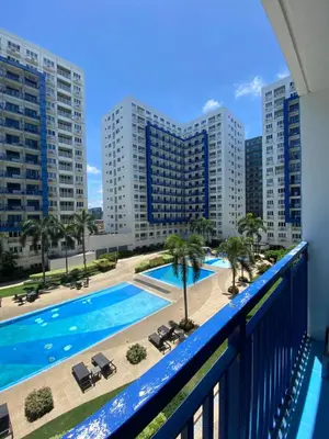 a balcony with a view of a pool and buildings at Sea Residences Santorini Vibes - Reynil in Manila