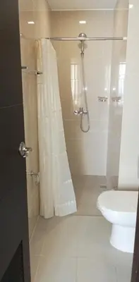 a bathroom with a shower with a toilet and a sink at The Verdin Brand-New Unit with Pool, Gym, & High-Speed Wi-fi in General Trias