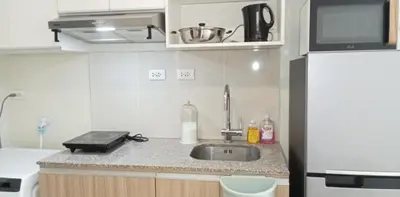 a kitchen with a sink and a refrigerator at The Verdin Brand-New Unit with Pool, Gym, & High-Speed Wi-fi in General Trias