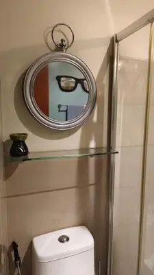 a bathroom with a mirror and a white toilet at Studio Premier Suite Makatii by Christine Suites PH in Manila