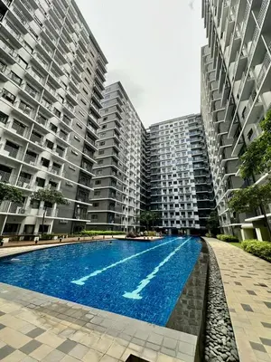 a swimming pool in front of two tall buildings at Mall of Asia shore 3 Tower 21661 Residence in Manila