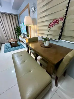 a dining room with a wooden table and a bench at Mall of Asia shore 3 Tower 21661 Residence in Manila