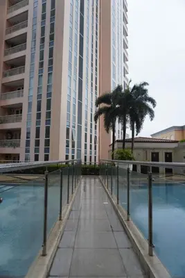 a walkway with palm trees in front of tall buildings at Modern Rustic Pet Friendly Condo in Mckinley Hill BGC in Manila