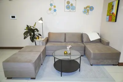 a living room with a couch and a table at Modern Rustic Pet Friendly Condo in Mckinley Hill BGC in Manila