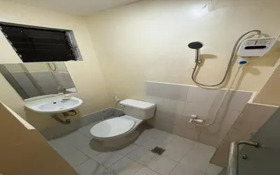 a bathroom with a toilet and a sink at San Antonio's Place Suites in Manila