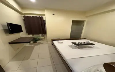 a small room with a bed and a table at San Antonio's Place Suites in Manila