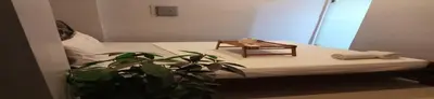 a bed with a table and a plant in a room at San Antonio's Place Suites in Manila